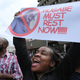 A woman holds up a banner among crowds marching on the streets of Harare, Zimbabwe, on Nov. 18, 2017, demanding the departure of President Robert Mugabe. (Tsvangirayi Mukwazhi/AP Images)